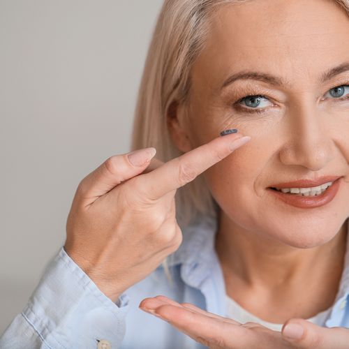 Woman putting on contact lens
