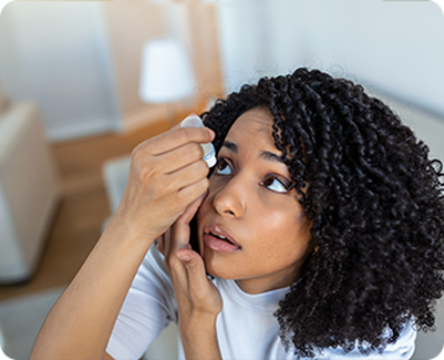 Woman with curly hair applying eyedrops