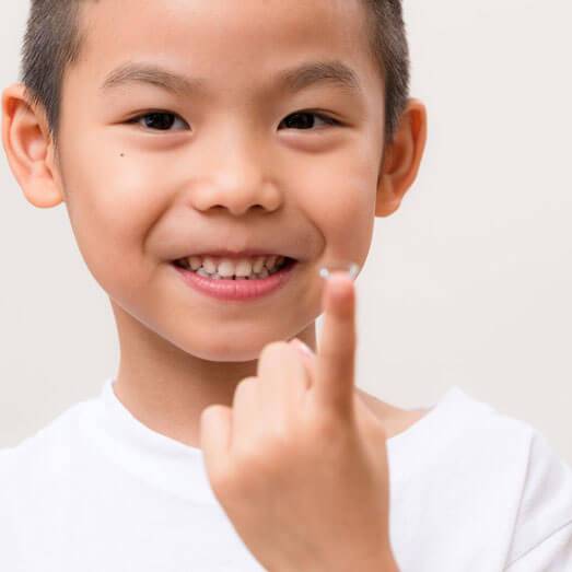 Child with myopia putting contact lenses in