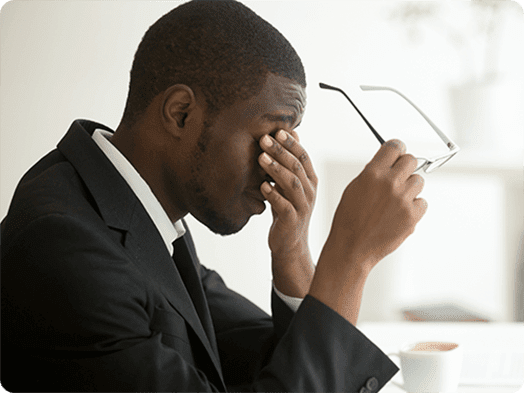 Man touching eyes and holding eyeglasses