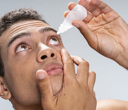 Man applying eye drops from Washington Eye Doctors to the eyes