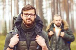 Man with a backpack and beard and his friend in forest