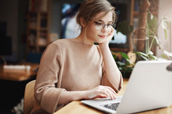 Woman wearing glasses using Macbook