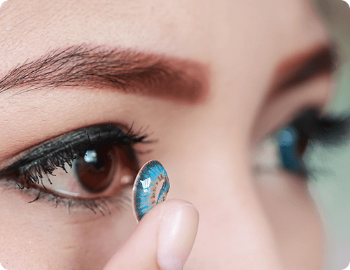 Woman putting on contacts in eye