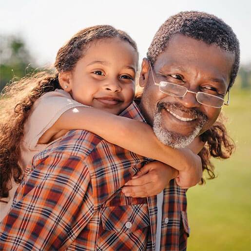 Old man wearing glasses giving piggy back ride with little girl