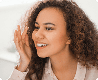 Woman putting-on blue light protection contact lenses