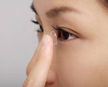 Woman putting on multifunctional scleral lenses from Washington Eye Doctors