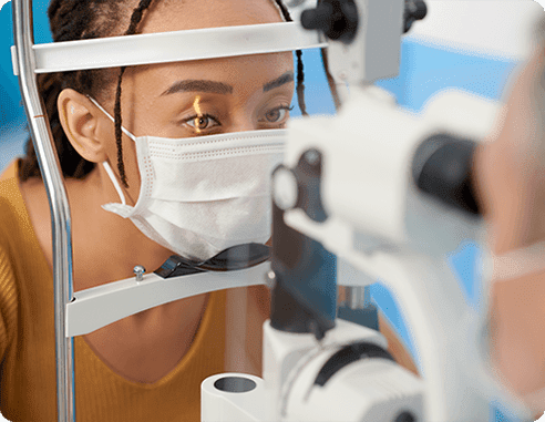 Woman wearing mask getting an eye exam