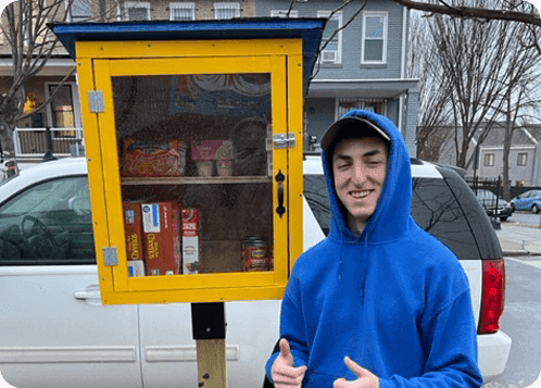 Kid smiling beside food collection box